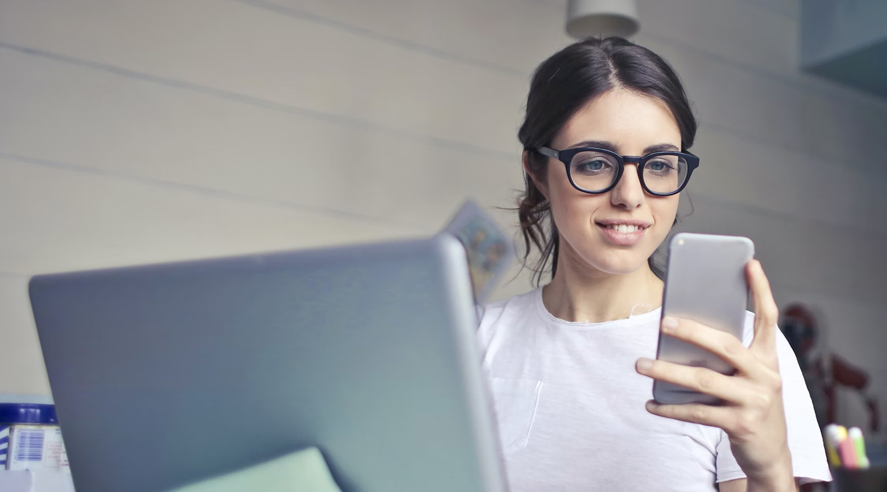 Woman working at desk looking at phone