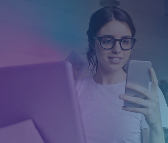 Woman working at desk looking at phone