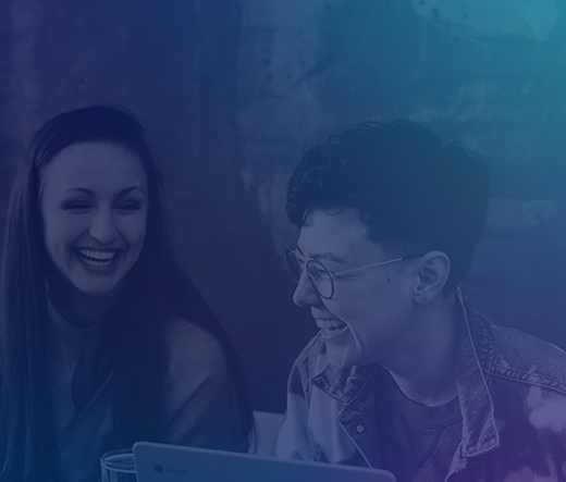 Millennials sitting around desk in working space laughing together