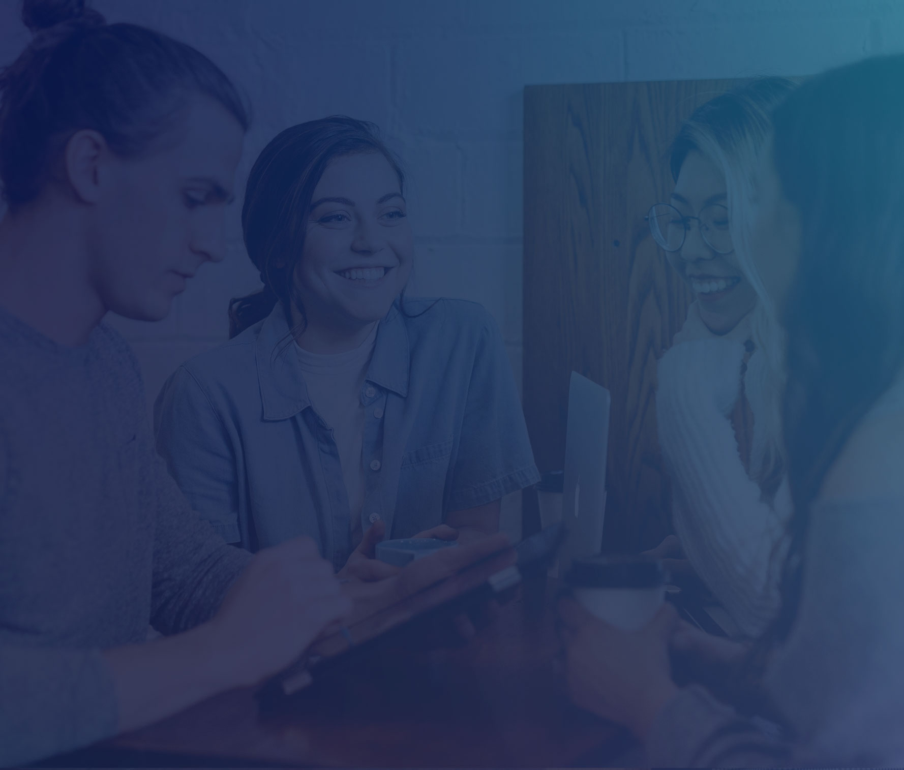 Group of people collaborating around a laptop