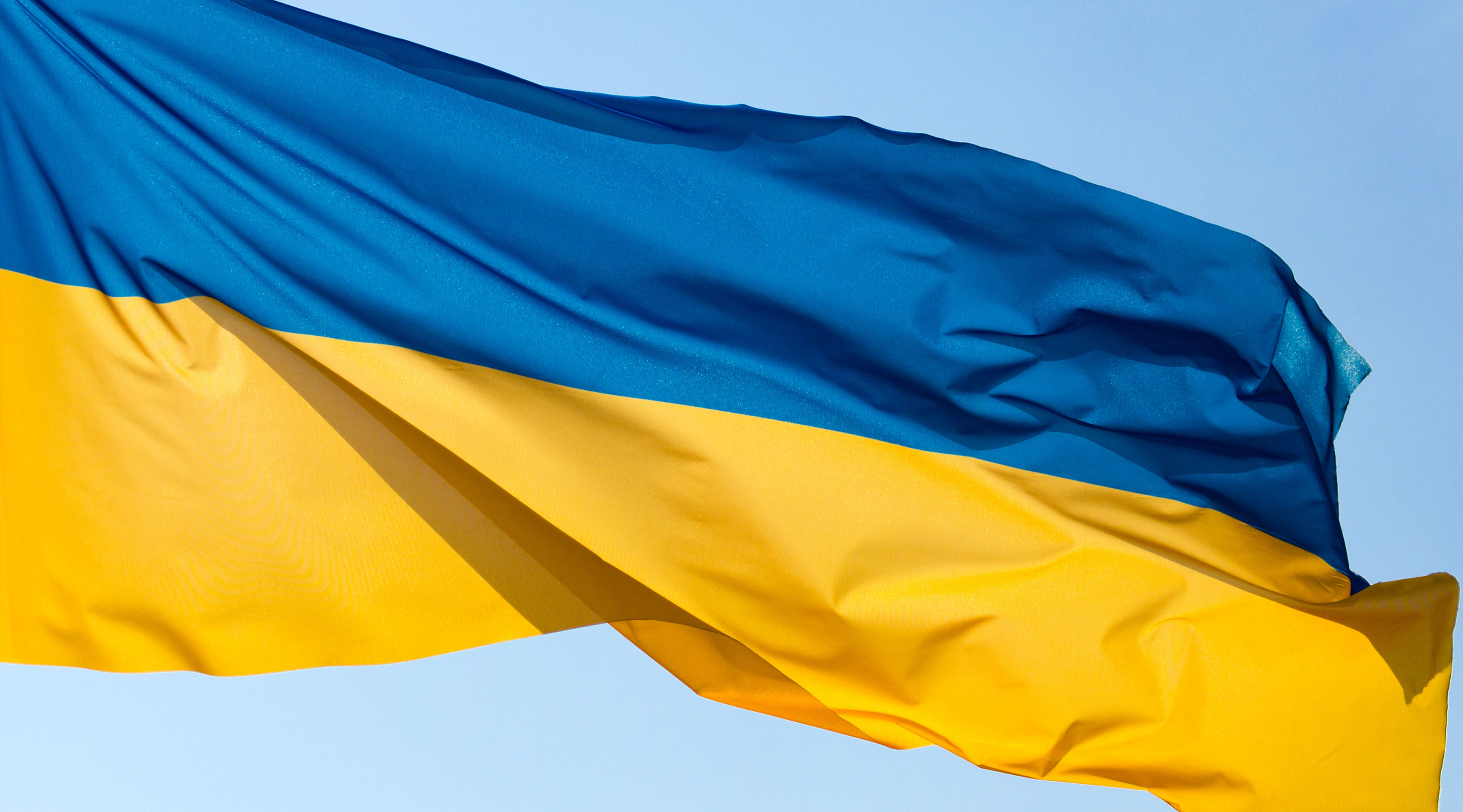 Ukrainian flag blowing in the wind against blue sky