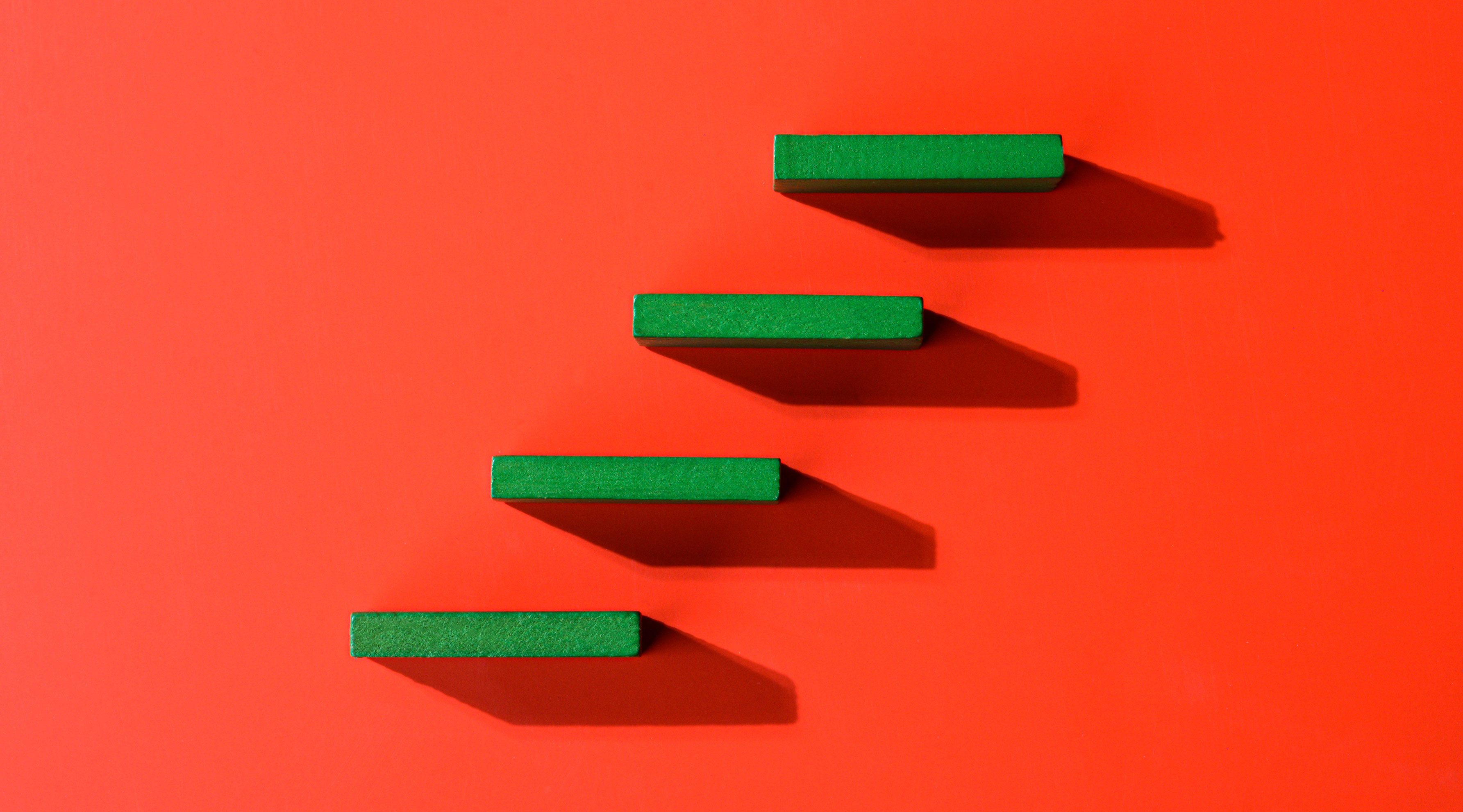 Four ascending green steps against a red background