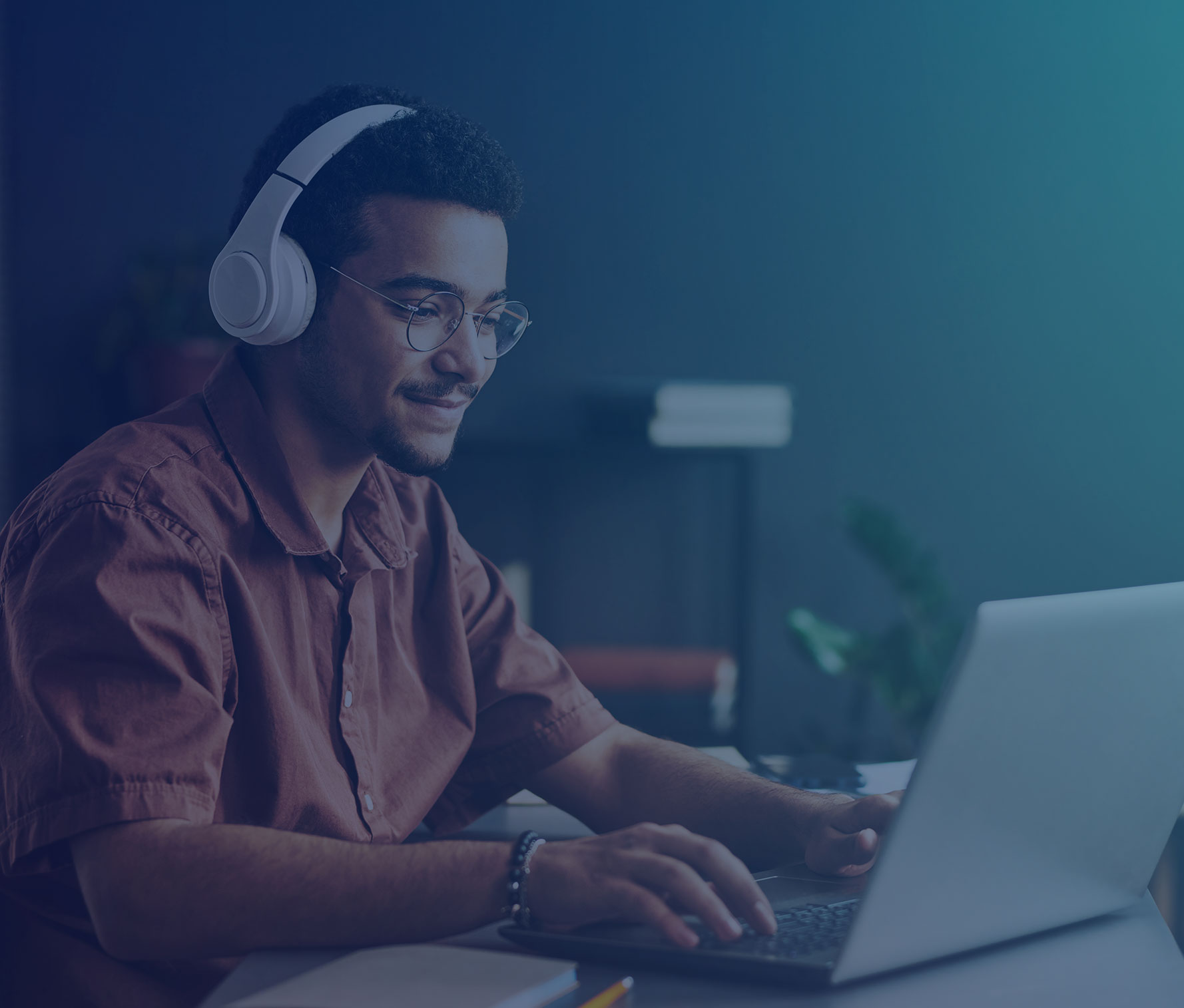 Young man wearing headphones using a laptop to take a course on an LMS
